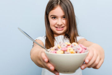Little caucasian girl holding a cereal bowl