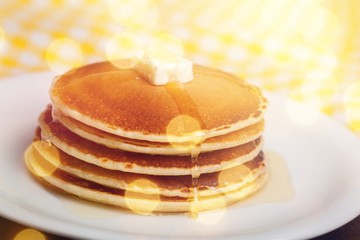 Stack of Small pancakes in syrup on background