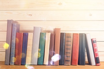 Ancient books in a row on wooden background