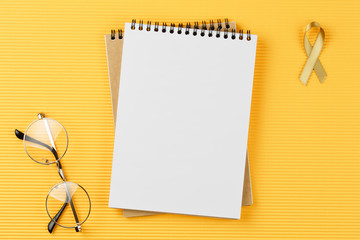 gold ribbon on open notebook isolated on yellow background