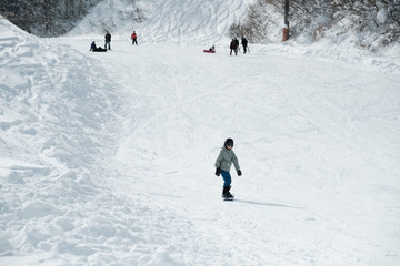 Fototapeta na wymiar Young preteen boy first time snowboarding in Japan, teen travel, fun winter activity for tourist