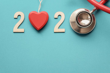 2020 wooden number with red stethoscope. Happy New Year for heart health and medical concept, life...