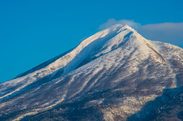 Fototapeta na wymiar 青空に真っ白な雪を被った磐梯山との美しいコントラスト