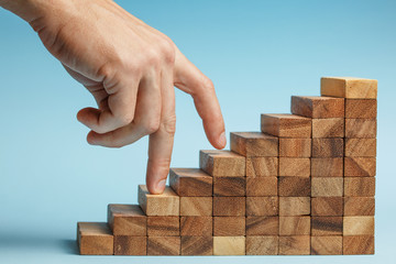 hand finger walk on stacked wooden block like stairs.