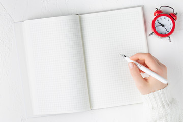 notebook with empty sheet on a white background with pen in hands