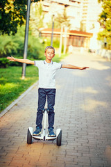 boyl  rides whirl on a hoverboard over park paths