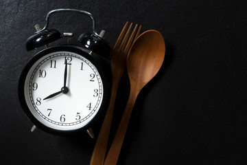 Food alarm clock spoon and fork, Healthy food concept on black background