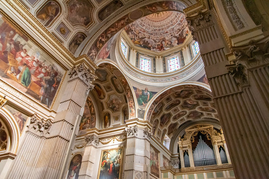 Severous colorful frescoes decorating walls and dome inside catholic cathedral in Italy