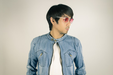 Young Asian Man in Jeans or Denim Jacket Wear Red Glasses Look Right Frame in Vintage Tone
