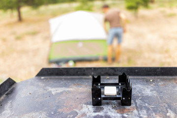 Campsite with man setting up tent and closeup of camp stove on grill on Canyon Rim Campground in Flaming Gorge Utah National Park