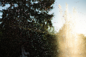abstract water splashes from the fountain in the city public park against the sky
