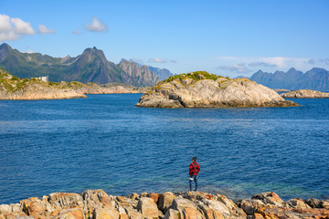Tourists stand on the rocks to see the great natural panoramic view at Kabelvaag In the Lofoten Islands, northern Norway.
