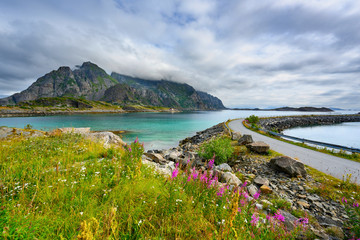 Viewpoint close to Henningsvaer, mountains, sea and rocks during the cloudy season in summer at the Lofoten Islands in Henningsvær, northern Norway