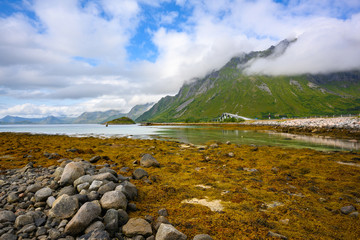 panoramic view at Gimsoystraumen Barstrand, Norway. The mountains and the blue sky during the day by the sea overlook the beautiful bridge.