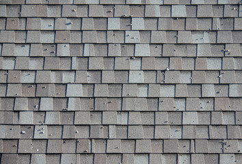 Close-op full frame view of a roof made with strips of asphalt shingles