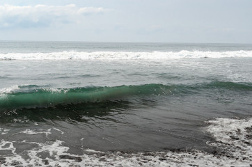 Waves breaking on black sand beach