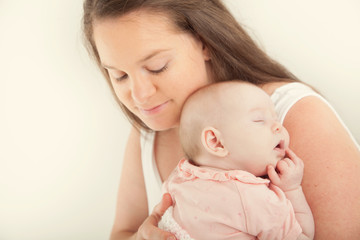 Fototapeta na wymiar New mother shooshing baby to sleep on shoulder