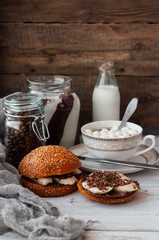 sandwich with chocolate-milk paste, bananas and nuts with coffee on a white table