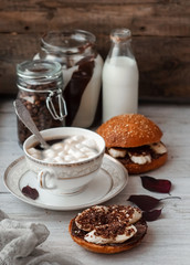 sandwich with chocolate-milk paste, bananas and nuts with coffee on a white table