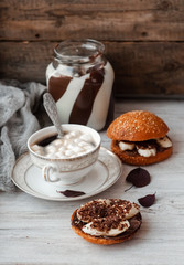 sandwich with chocolate-milk paste, bananas and nuts with coffee on a white table