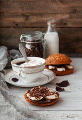 sandwich with chocolate-milk paste, bananas and nuts with coffee on a white table