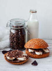 sandwich with chocolate-milk paste, bananas and nuts with coffee on a white table
