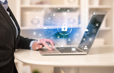 Business woman below chest working on laptop in a cozy homey environment with secured connection concept