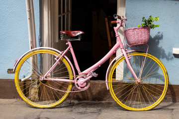 Fototapeta na wymiar Rosa Fahrrad als Deko vor blauem Hauseingang, Südengland