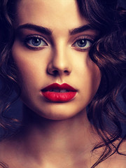 Fototapeta premium Face of a beautiful woman with a smoky eye makeup and red lipstick