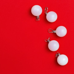 New Year glass white balls on red background. Creative holiday christmas concept. Minimal style. Flat lay. Top View.