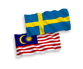 National vector fabric wave flags of Sweden and Malaysia isolated on white background. 1 to 2 proportion.