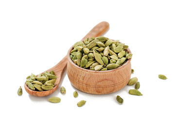 Cardamom pods in a wooden bowl isolated on white background.