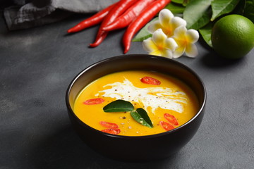 Thai spicy pumpkin and coconut milk soup with kaffir lime leaves , red chilli and galangal roots powder. Vegan, healthy food, gluten-free. Paleo-diet