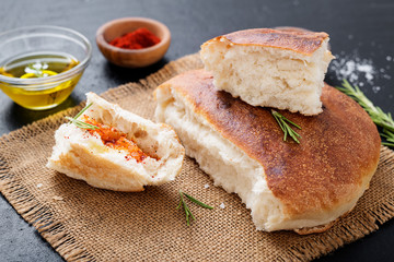 Fresh hot focaccia bread (pita) served with olive oil, paprika and rosemary.