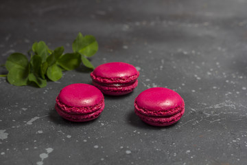 Colorful french macarons cookies(macaroons) on a dark background with copy space. Dessert for served with tea or coffee break.