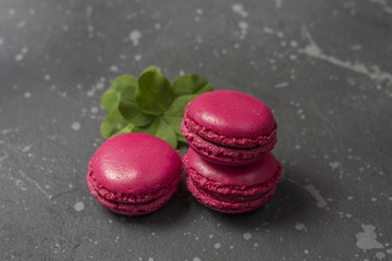 Colorful french macarons cookies (macaroons) on a dark background. Dessert for served with tea or coffee break. Holiday gift for women.
