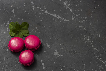Colorful french macarons cookies (macaroons) on a dark background. Dessert for served with tea or coffee break. Holiday gift for women.