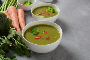 Healthy Vegan Creamy blended vegetable Soup puree with broccoli, celery, peas and carrots . Green detox soup concept. Low-fat lunch.