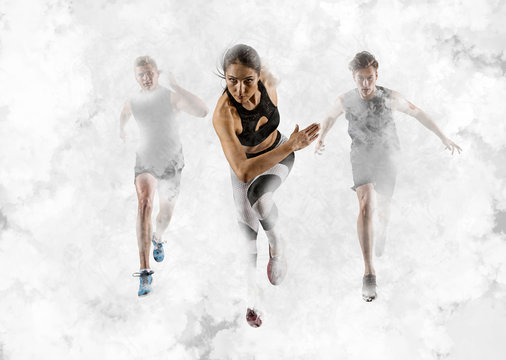 Men and woman running on smoke background. Mixed image