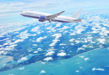 Obraz na płótnie Canvas Plane flying over beautiful blue ocean and singapore island.