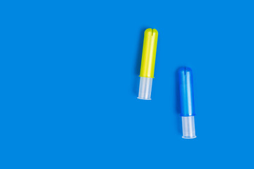 Blue and yellow plastic tampon applicators isolated on vivid blue ba