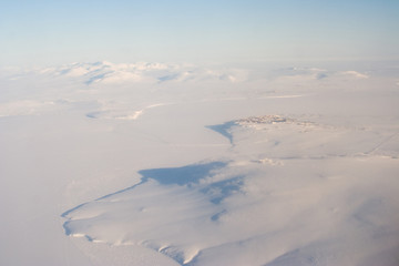 Naklejka na ściany i meble Aerial arctic landscape. Top view of the snowy expanses of the Arctic. The small northern city of Anadyr and its environs. Anadyr estuary and hills. Anadyr, Chukotka, Siberia, Far East Russia. Winter.