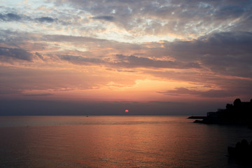 Fototapeta na wymiar Magnificent sunrise over the sea and beautiful cloudscape on the coast of Sicily. Cefalu, Italy