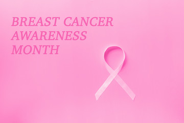 Sweet pink ribbon shape on pink background for Breast Cancer Awareness symbol to promote in october month campaign. Flat lay with copy space, top view, mockup, overhead, template. Health care concept