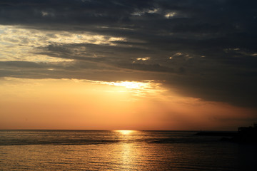 Obraz premium Magnificent sunrise over the sea and beautiful cloudscape on the coast of Sicily. Cefalu, Italy