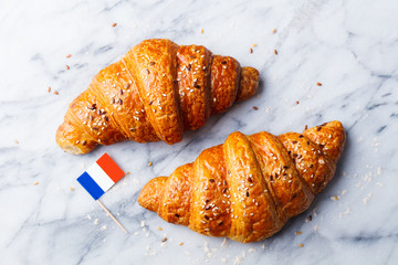 Fresh croissant with French flag on marble table background. Top view. Copy space.