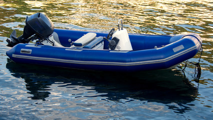 Inflatable small boat moored in the river, with evening light