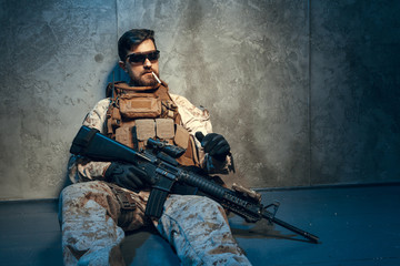 Fototapeta premium American private military contractor holding rifle. Image on a dark background
