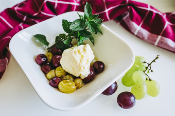 Dessert glace vanille raisins cuits menthe fraiche et coulis de framboise