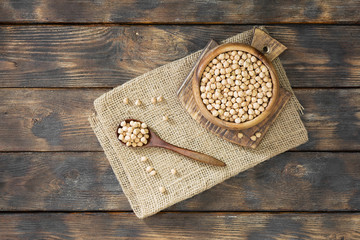 Chickpeas in a wooden bowl on a wooden table. Rustic style. Top view